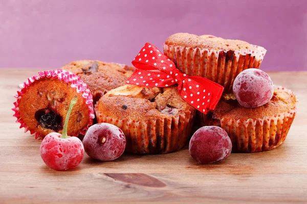 Versgebakken muffin bestrooid met poedersuiker en bevroren kersen — Stockfoto