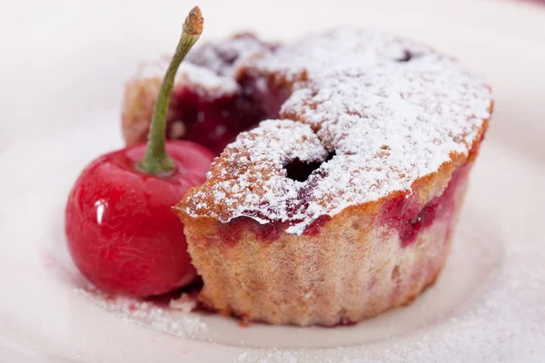 Pedaço de maffin e cerejas frescas em um prato — Fotografia de Stock