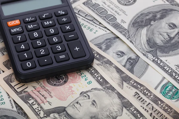 Calculator on the background of dollar banknotes — Stock Photo, Image