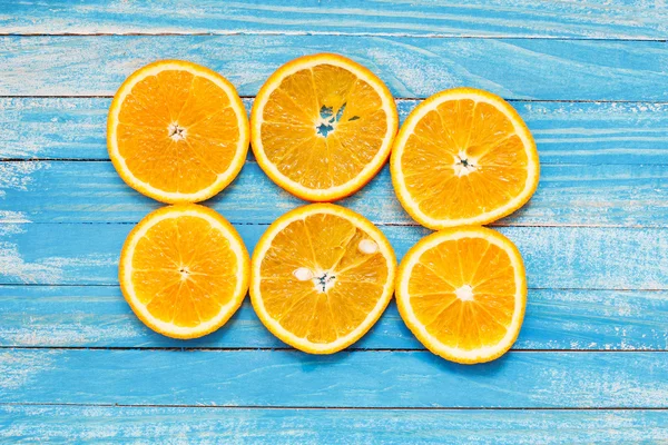 Mavi ahşap masa üzerinde taze portakal dilim — Stok fotoğraf