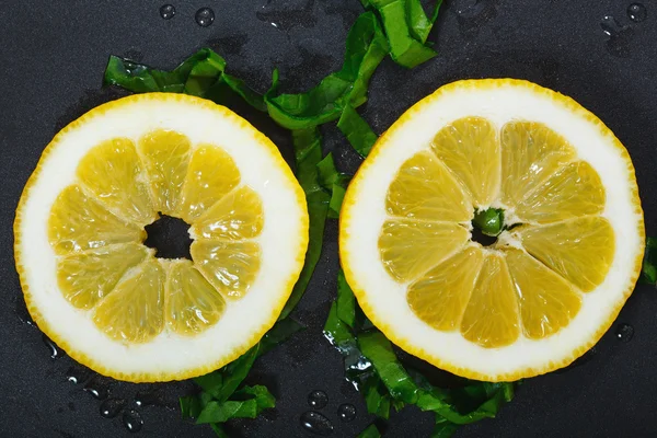 Bir tavada doğranmış ıspanak yaprakları limon dilimleri ile dekore edilmiş — Stok fotoğraf