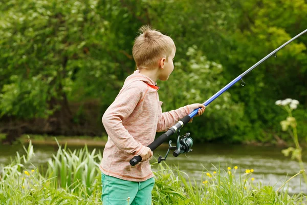 Mignon petit garçon pêche sur la rivière — Photo