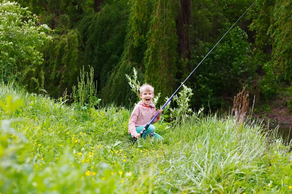 Lindo niño pequeño pesca en el río — Foto de Stock