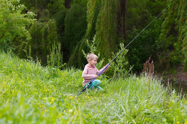 Mignon petit garçon pêche sur la rivière — Photo