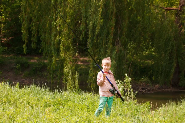 Photo du petit enfant tirant la canne pendant la pêche le week-end — Photo