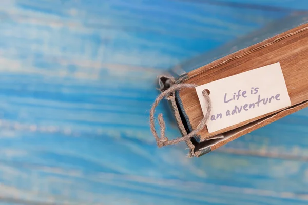 Life is adventure sign on old book - vintage style — Stock Photo, Image