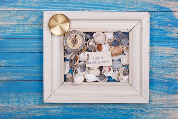 Compass, shell and sign life is adventure — Stock Photo, Image