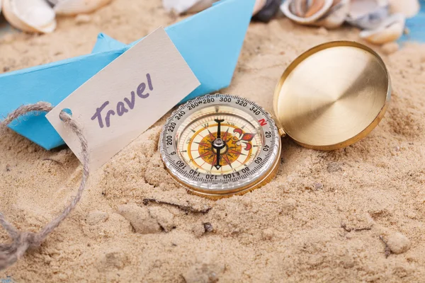 Compass in the sand with sign travel — Stock Photo, Image