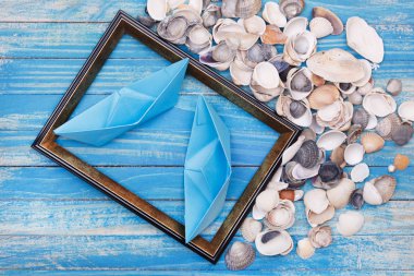 Mavi kağıt tekneler ve deniz kabukları fotoğraf çerçevesi içinde