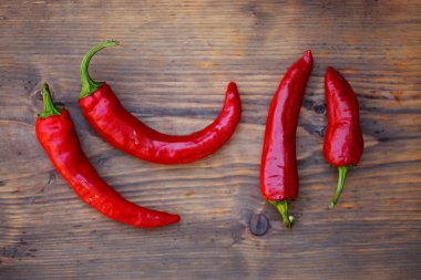 Eski bir ahşap masada taze kırmızı kırmızı biber grubu.