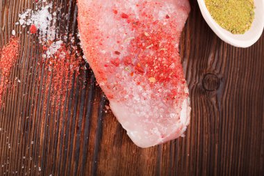 Koyu ahşap arka planda çiğ etli biftek.