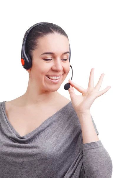 Retrato de feliz sonriente joven operador de teléfono de apoyo en auriculares que muestran el área de copyspace o algo, aislado sobre fondo blanco —  Fotos de Stock
