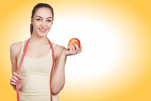 Beautiful athletic looks girl holding an apple — Stock Photo, Image