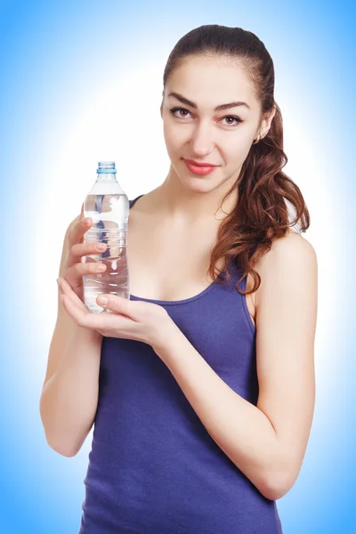 Hermosa chica atlética se ve sostener una botella — Foto de Stock