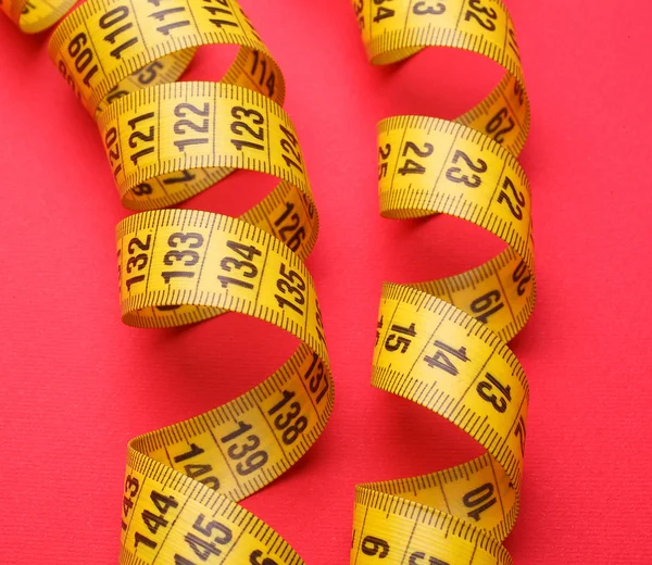 Nastro di misurazione giallo su fondo rosso — Foto Stock