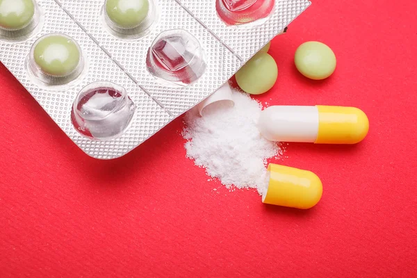 Pills and capsules on red background — Stock Photo, Image