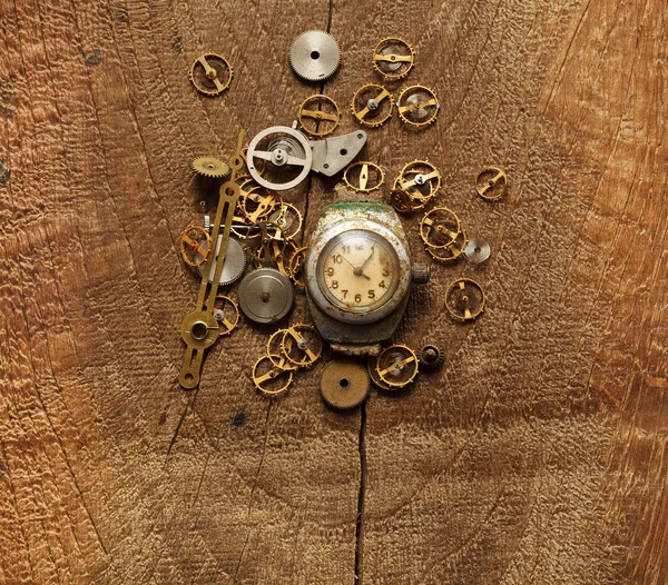 old watches and gears on wooden background