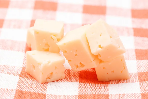 Cubos de queijo na toalha de mesa da cozinha — Fotografia de Stock