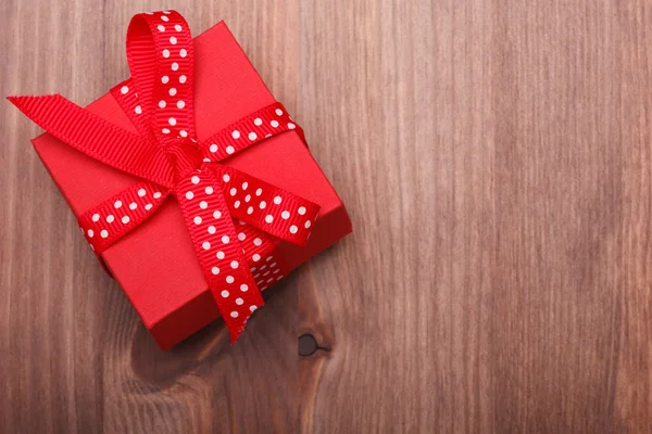 Rode luxe-geschenketui gebonden rood lint op houten tafel — Stockfoto