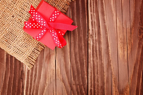 Caja de regalo roja atada cinta roja en mesa de madera —  Fotos de Stock