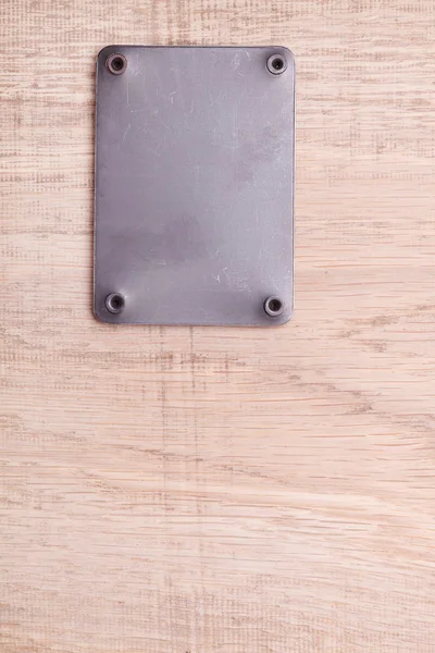 Un fondo de madera con etiqueta de metal —  Fotos de Stock