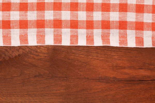 Mantel a cuadros rojo y blanco ondulado sobre mesa de madera — Foto de Stock