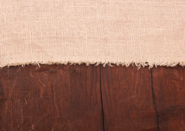 Burlap on wooden table — Stock Photo, Image