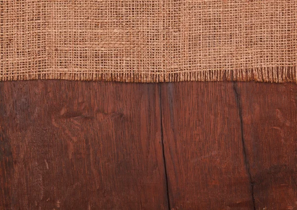 Burlap on wooden table — Stock Photo, Image