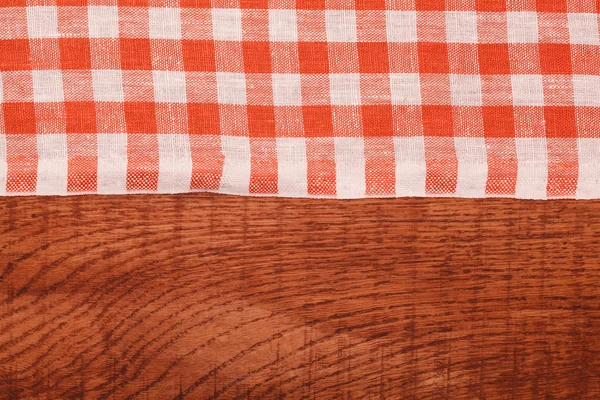 Mantel a cuadros rojo y blanco ondulado sobre mesa de madera —  Fotos de Stock