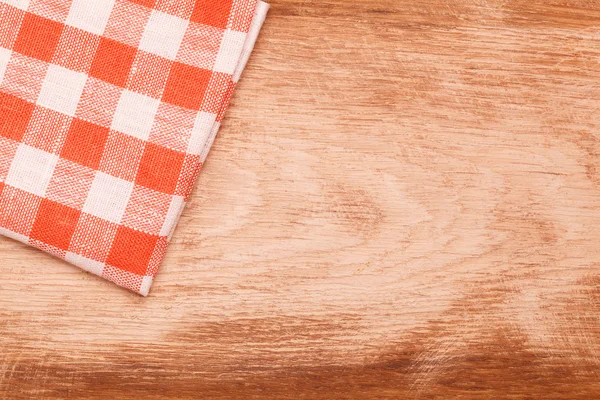Tovaglia a quadretti rossa e bianca ondulata sul tavolo in legno — Foto Stock