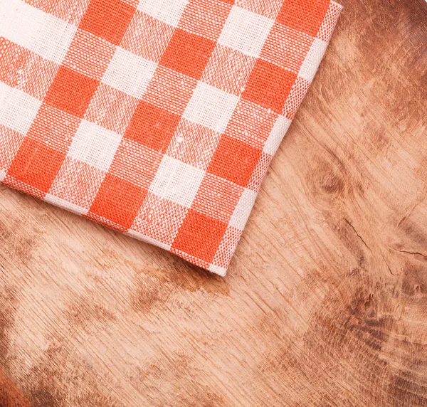 Tovaglia a quadretti rossa e bianca ondulata sul tavolo in legno — Foto Stock