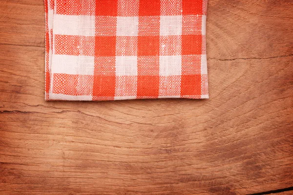 Mantel a cuadros rojo y blanco ondulado sobre mesa de madera —  Fotos de Stock