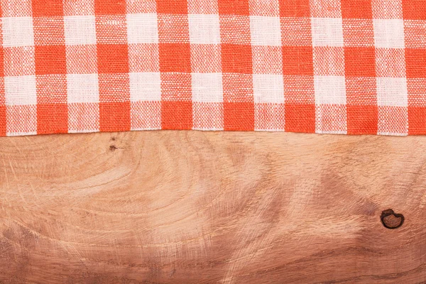 Mantel a cuadros rojo y blanco ondulado sobre mesa de madera — Foto de Stock