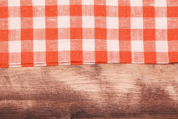 Mantel a cuadros rojo y blanco ondulado sobre mesa de madera — Foto de Stock