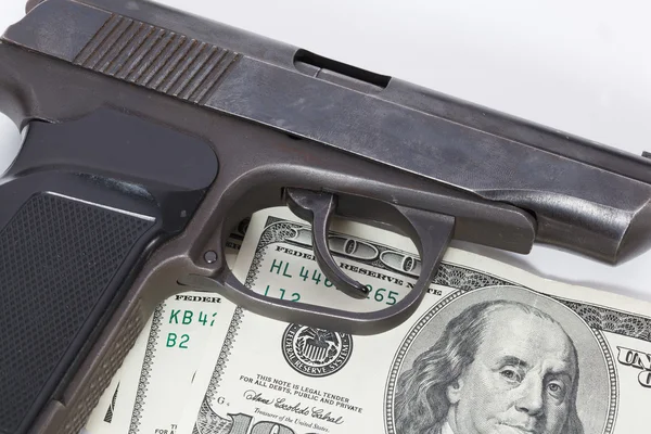 Black gun is lying on dollar bills — Stock Photo, Image
