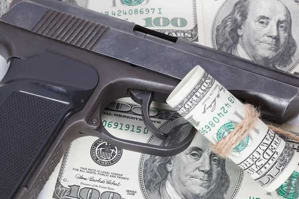 Black gun is lying on dollar bills — Stock Photo, Image