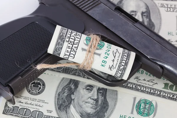 Black gun is lying on dollar bills — Stock Photo, Image