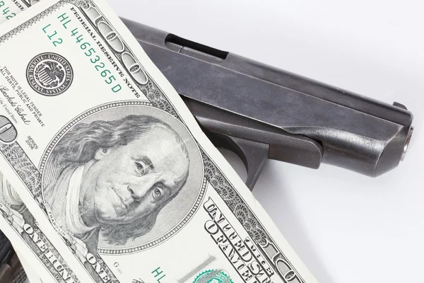 Black gun is lying on dollar bills — Stock Photo, Image