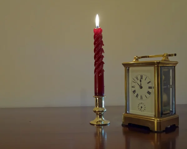 Candle and old bronze clock — Stock Photo, Image