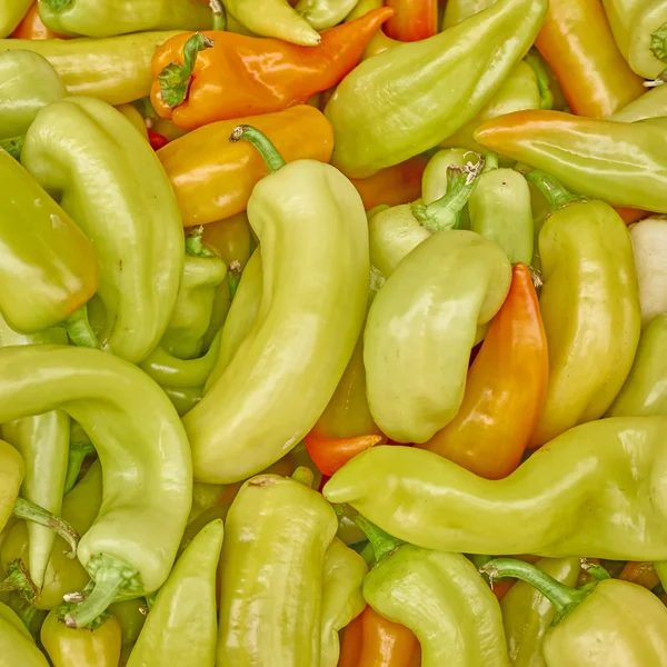 Tasty background, orange horn peppers closeup — Stock Photo, Image