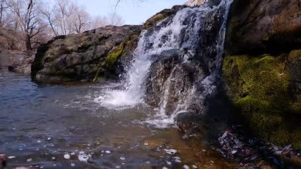 小さくて低い滝、苔で覆われた花崗岩の石から水が落ち浅い淡水川に落ち、スプラッシュが酸素を生み出す — ストック動画