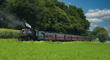 Strasburg, Pennsylvania, Temmuz 2007 - Güneşli bir günde Buharlı Yolcu Treni Küçük Kırsal İstasyondan Çıkmayı Bekliyor