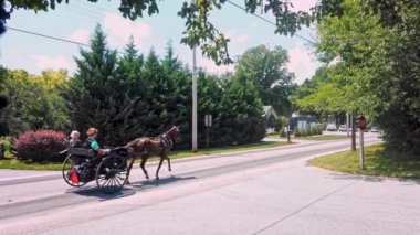 Gordonville, Pennsylvania, Ağustos 2020 - Amish Teenage Boy Güneşli bir yaz gününde bir kır yolunda scooter sürüyor