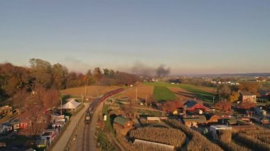 Antika Buhar Lokomotifi 'nin hava görüntüsü, öğleden sonra geç saatlerde Yolcu Arabaları Çekme ve Duman ve Buhar Patlaması' na yaklaşıyor.
