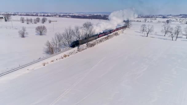 ペンシルベニア州ロンクス 2021年2月 雪の嵐の後に乗用車を引っ張り煙と蒸気を吹いて接近するアンティーク蒸気機関車の空中ビュー — ストック動画