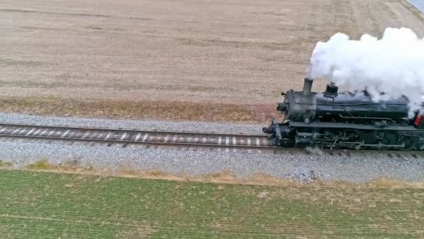 冬日里 带着汽笛的蒸汽机车沿着侧风吹来的浓烟和蒸汽机车在乡间穿梭的空中近景 — 图库视频影像