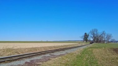 Yaklaşan Buharlı Yolcu Treni Güneşli bir günde duman ve buhar üflüyor