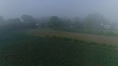 Sabahın erken saatlerindeki sisli hava manzarası Çiftlik arazileri, evler ve iş yerleri üzerine kurulmuş.