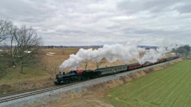 Bir Buhar Lokomotifi 'nin insansız hava aracı görüntüsü Yolcu Koçlarının Kırsal bir günde Buhar Başı ile yaklaşması