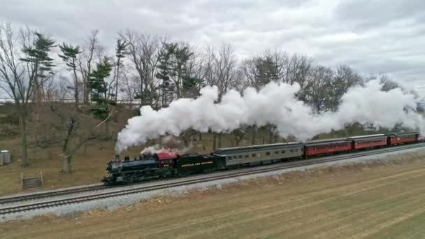 ペンシルベニア州ロンクス 2021年3月 冬の日に田舎の蒸気機関車の頭がいっぱいに近づく旅客コーチ付き蒸気機関車のドローンビュー — ストック動画